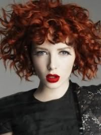 Дневной макияж с акцентом на ярко-красных губах идеально смотрится с укладкой волос рыжего оттенка в виде мелких локонов