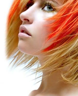Короткая рваная стрижка для блондинок великолепно гармонирует с мелированием яркого оранжевого оттенка и макияжем с черной тушью, розовыми румянами и блеском для губ натурального цвета