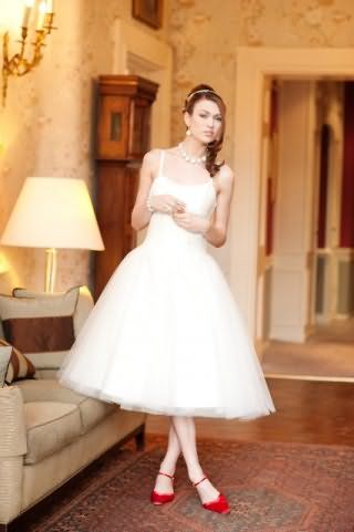 Изящное платье в стиле 50-х белого цвета, на бретелях, облегающего фасона, с пышной юбкой.